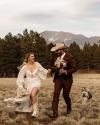 a woman in a field in a wedding dress, white cowgirl boots and a white cowboy hat
