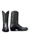 A pair of black cowboy boots with green stitching and decorative patterns, shown against a black background.