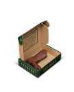 An open Tecovas box displays a small, brown leather item shaped like a cowboy boot, with a printed message on the inside lid.