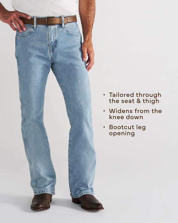 A person wearing light blue jeans, a brown belt, brown leather boots, and a white shirt stands against a plain background.