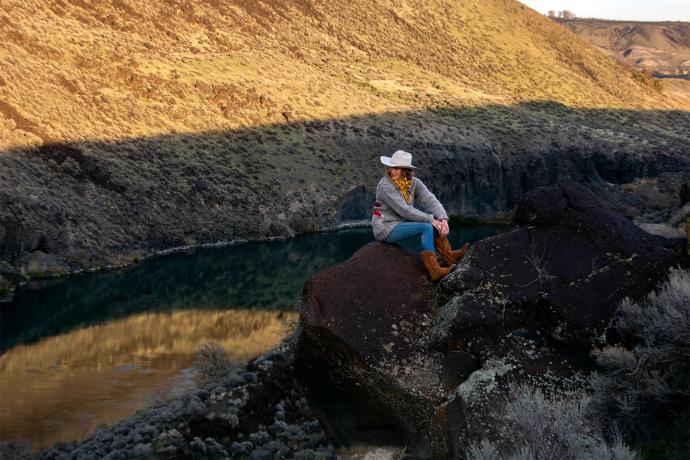 woman sitting on the edge of cliff