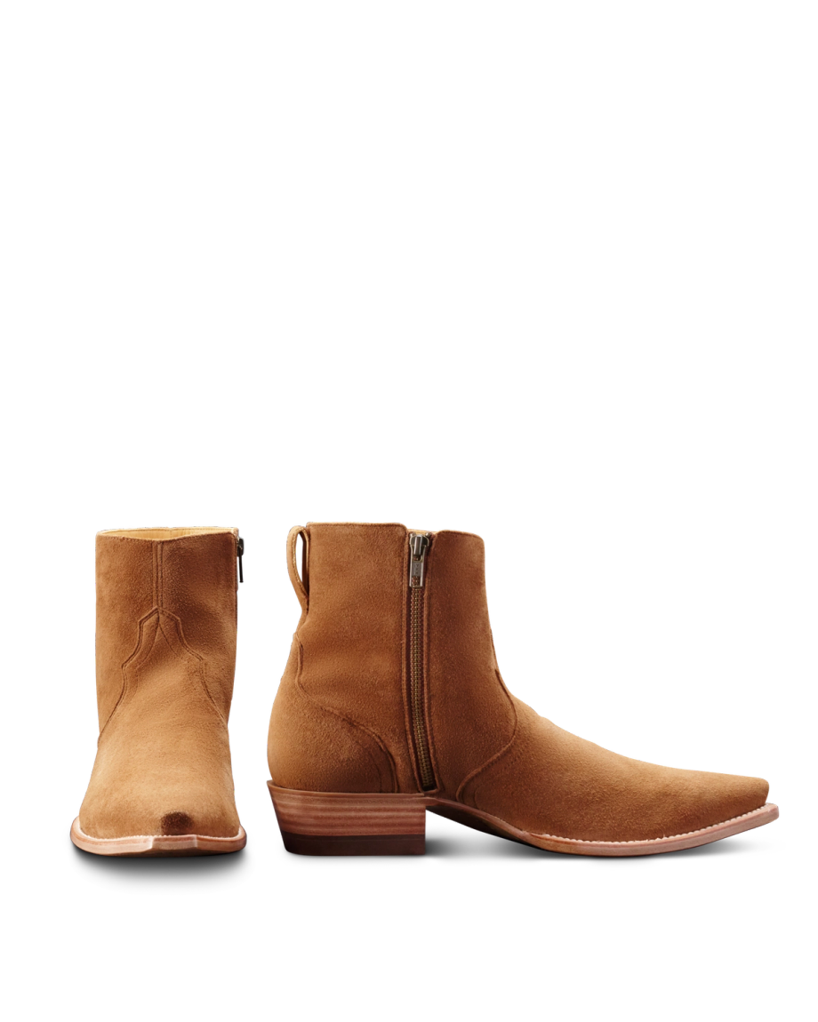 A pair of brown suede ankle boots with zippers. One boot is upright and front-facing, and the other is side-facing, showing the wooden heel and pointed toe.