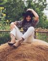Woman sitting on hay bail with The Sadie by Kristopher Brock boots on