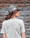 Back view of a woman wearing the olive trucker hat