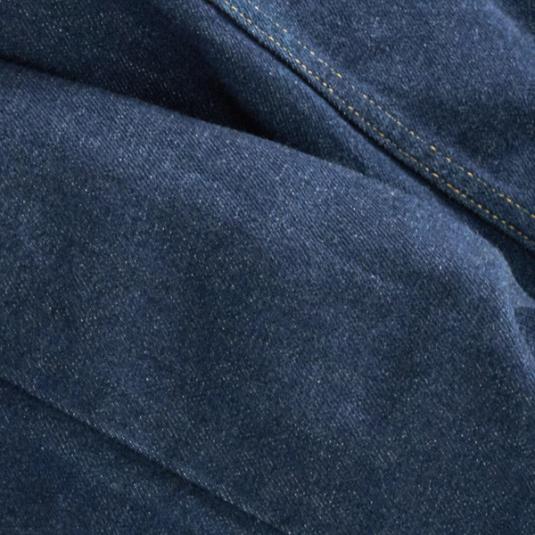 Close-up of dark blue denim fabric with visible stitching and fold lines.
