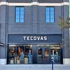 A wall with various shades of brown leather panels featuring the word "Tecovas" in white script lettering.