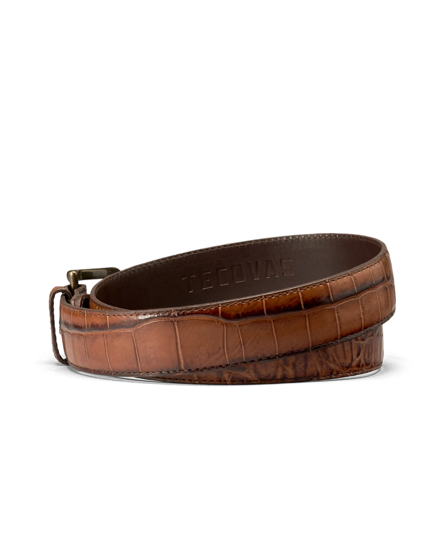 Coiled brown embossed leather belt with a metal buckle and the Tecovas brand name stamped on the interior.