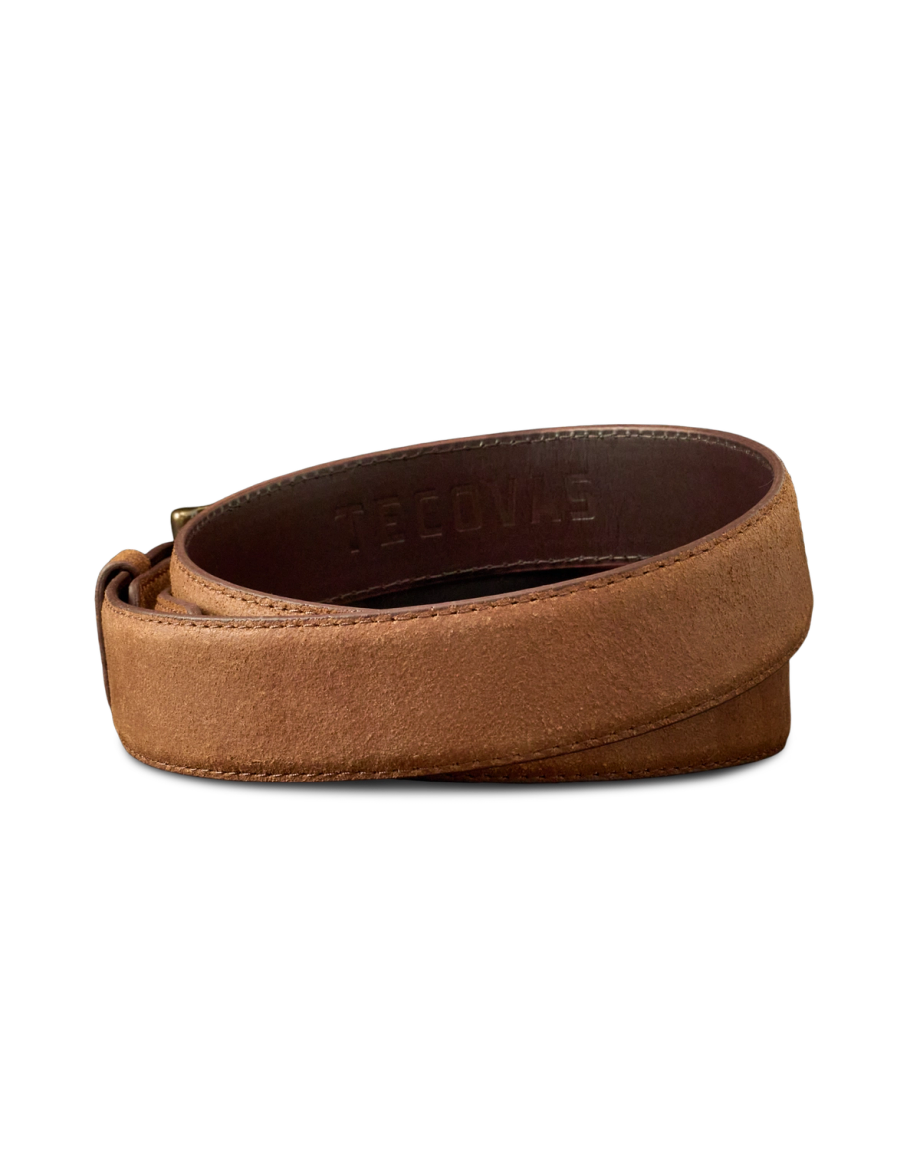 A brown leather belt with a suede finish, coiled and showing the embossed word "Tecovas" on the inner side.