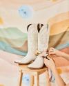 The limited edition Mother's Day Scarf tied around The Annie cowgirl boot in Bone.