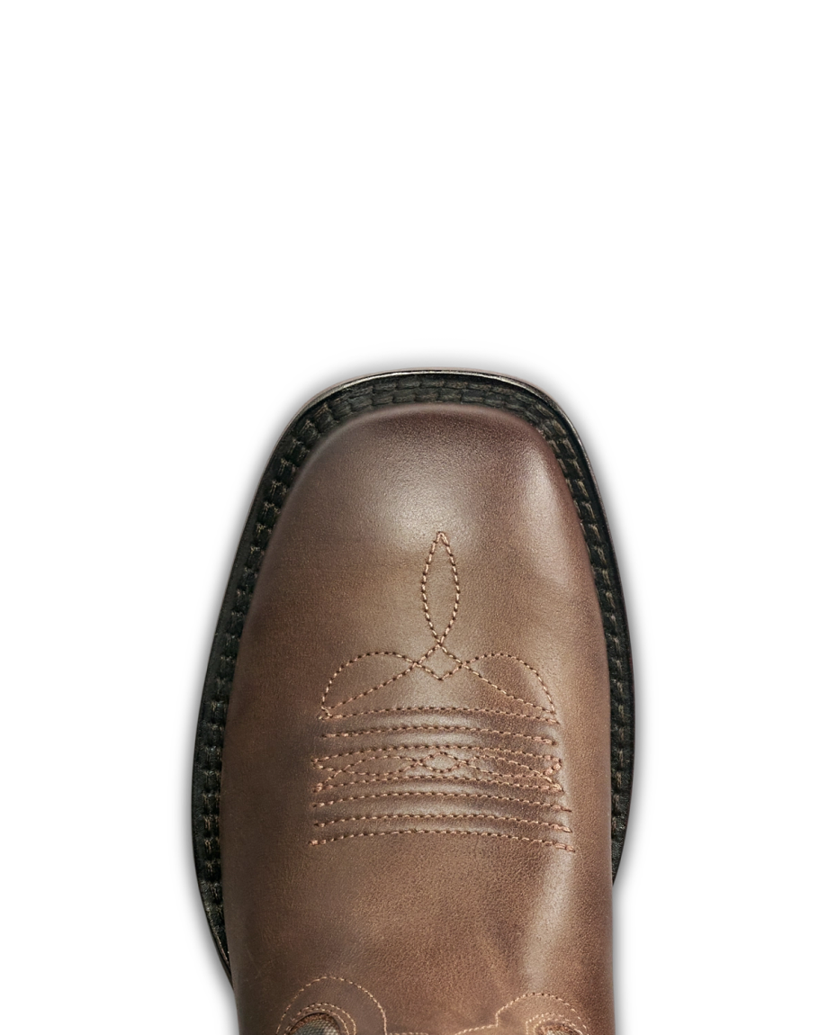 A close-up view of the toe of a brown leather boot with decorative stitching and a black sole, photographed from above.