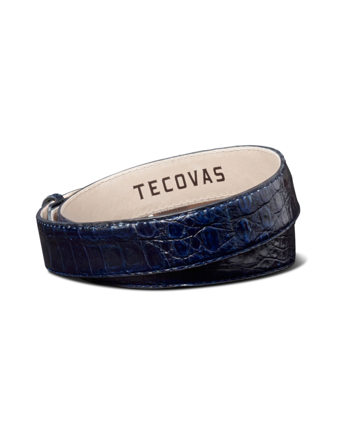 A blue, textured leather belt coiled with the brand name "Tecovas" inside.