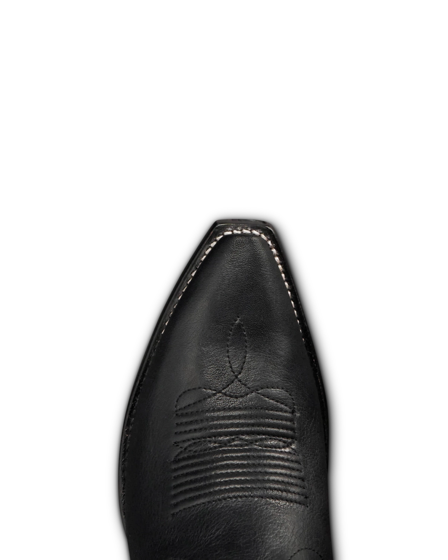 Close-up of the pointed toe of a black leather western boot, named The Annie Cowhide, with visible stitching and decorative embroidery in rich midnight tones.