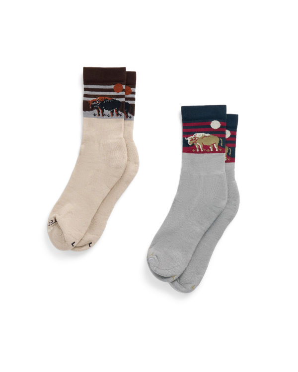 Two pairs of socks: one beige with a bear design and one light blue with a bison design, both featuring nature-themed patterns near the cuffs.