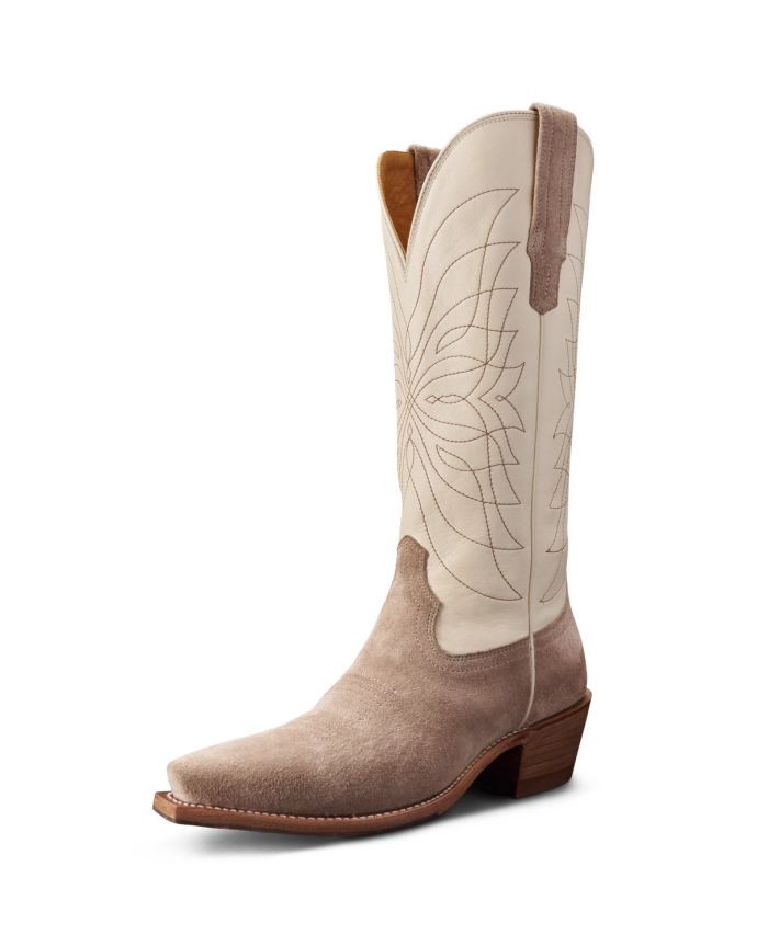 A single cowboy boot with a light beige upper, decorative stitching, and a tan suede lower section. It features a pointed toe and a wooden heel.