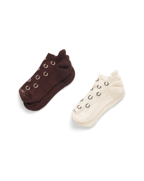 Two pairs of ankle socks, one brown and one white, each with a repeating crescent pattern, displayed on a plain white background.