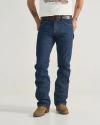 A person wearing blue jeans, a white t-shirt, a black belt, and brown cowboy boots stands against a plain background. Their hands are behind their back.