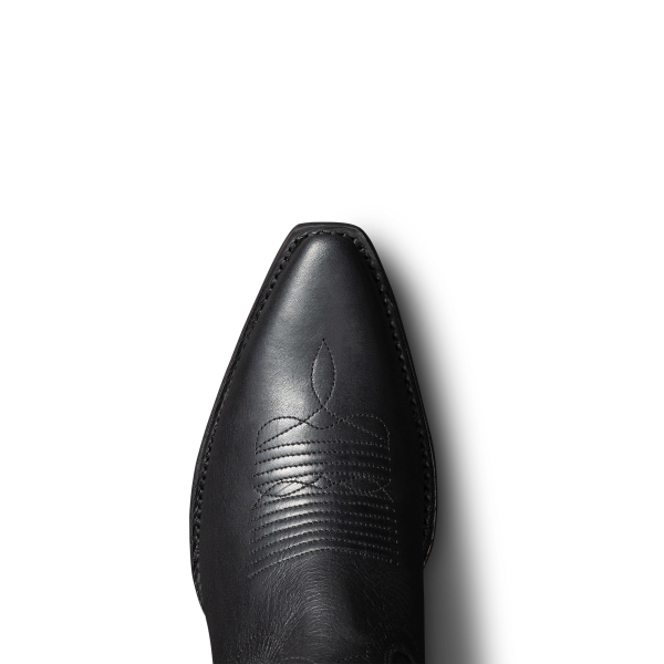 Top view of a black cowboy boot featuring intricate stitching on the toe, set against a plain black background.
