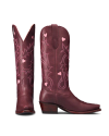A pair of maroon cowboy boots with pink heart and swirl embroidery, pointed toes, and angled heels.
