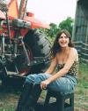 Woman wearing Kristopher Brock The Floral Ranch Scarf as a top sitting by a tractor - Tecovas 