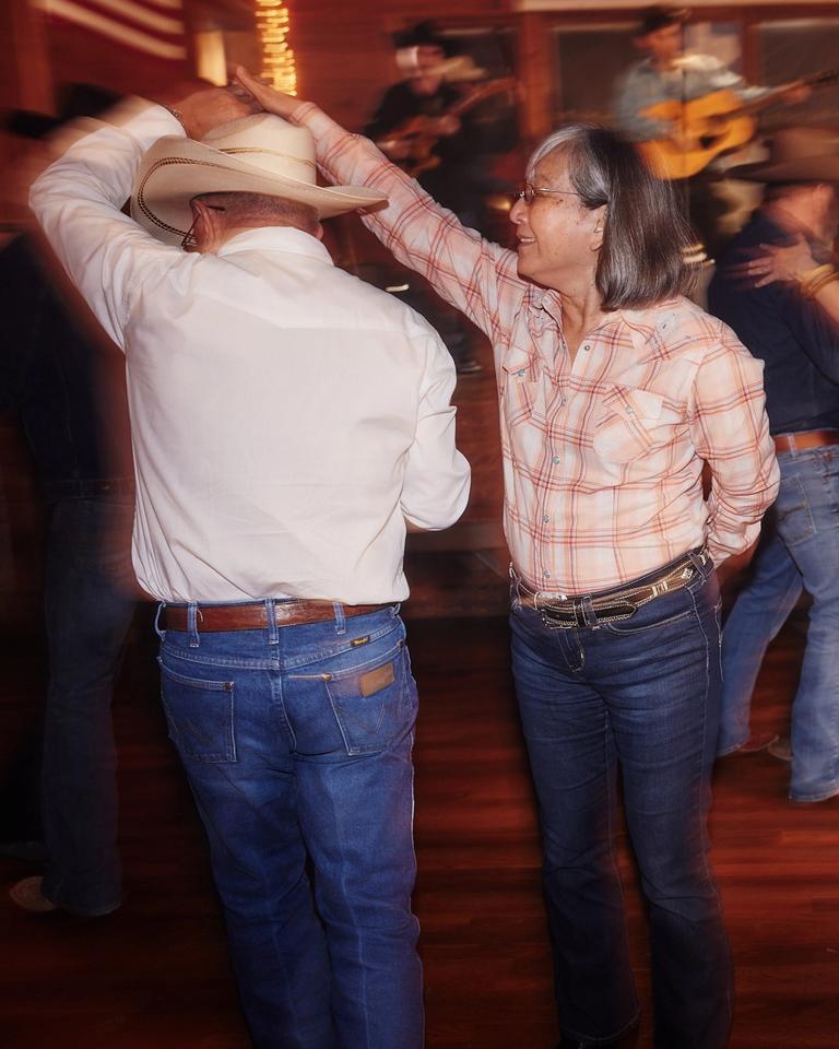 A man in a cowboy hat is dancing with a woman.