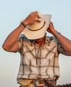 Man wearing Cattleman Cowboy Hat at Golden Hour. 