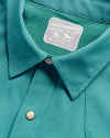 Close-up of a teal Western-style shirt showing a button and a label indicating a medium size, performance material, and classic fit.