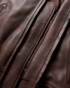 Closeup of the leather bomber jacket showing the embossed Tecovas logo