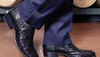 Man in suit wearing black ostrich boots