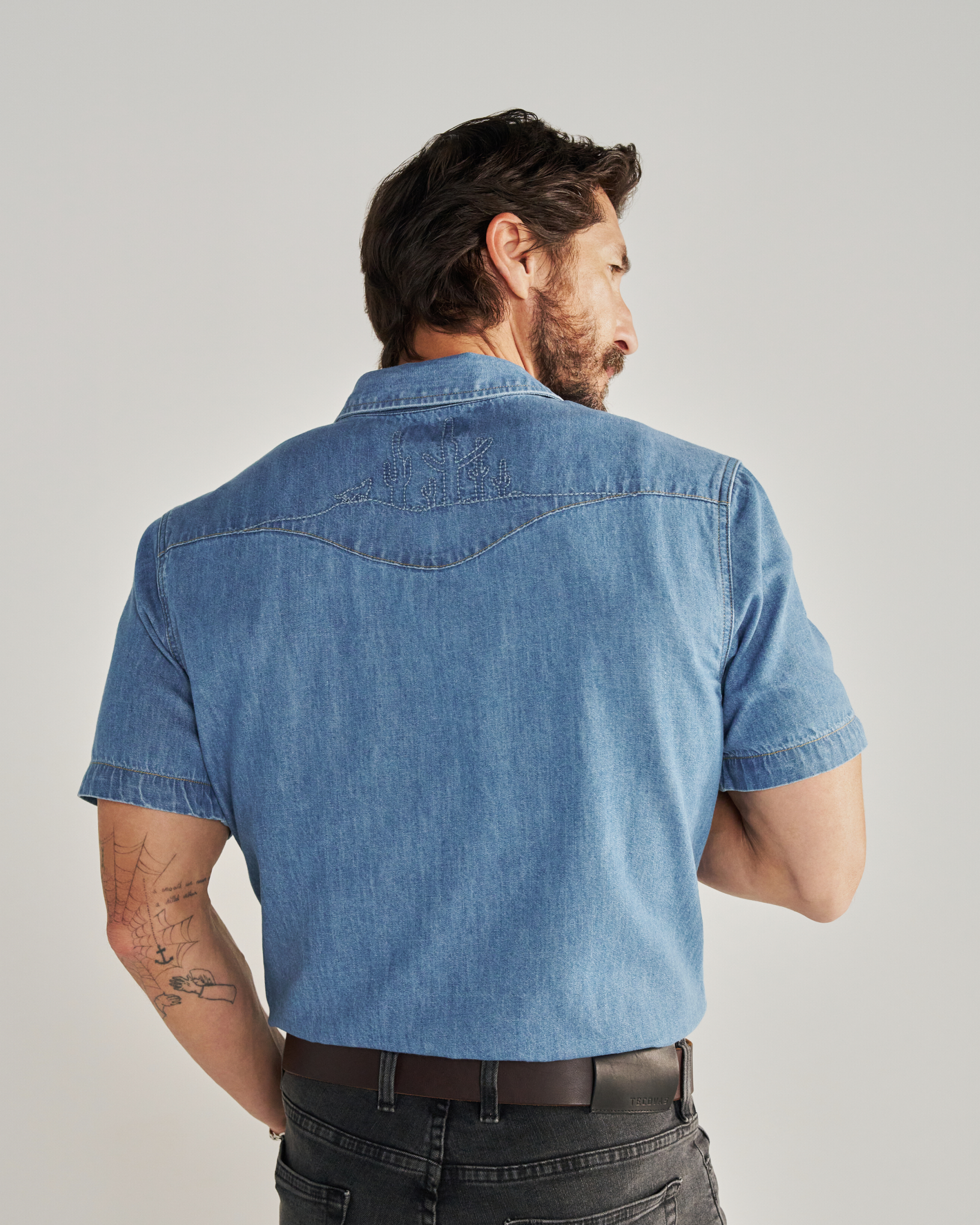 Closeup detail view of Men's Denim Pearl Snap SS - Turquoise / Multi