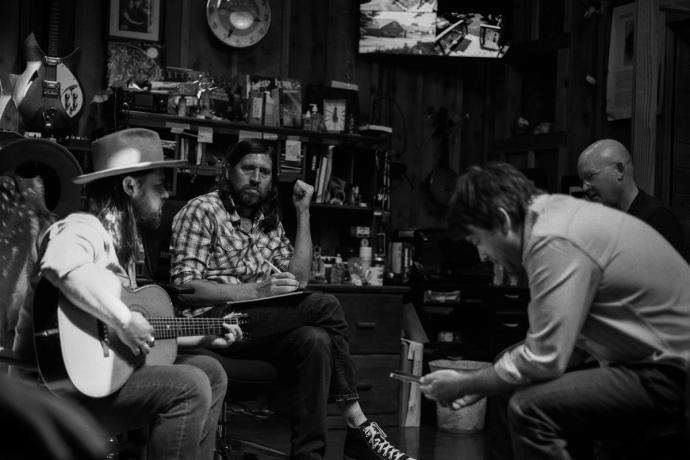 black and white image of men writing music