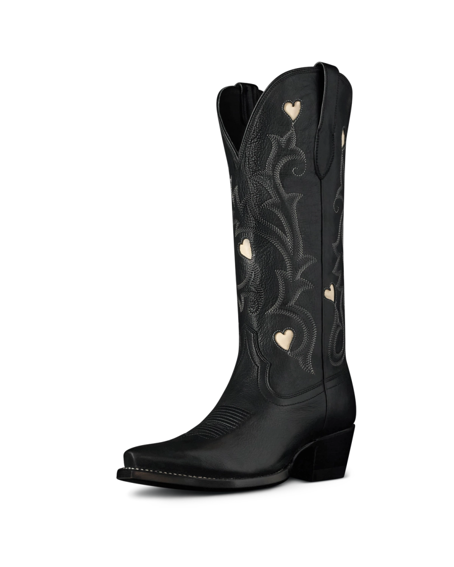 The Annie in Midnight Cowhide. Black leather cowboy boot crafted from premium Midnight Cowhide, featuring embroidered patterns and small heart-shaped cutouts on the shaft, shown against a plain white background.