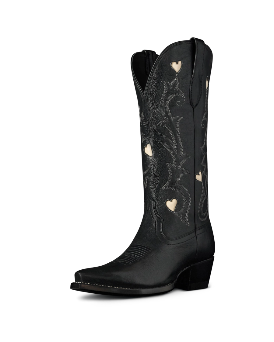 The Annie in Midnight Cowhide. Black leather cowboy boot crafted from premium Midnight Cowhide, featuring embroidered patterns and small heart-shaped cutouts on the shaft, shown against a plain white background.