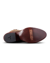 Underside view of a brown leather shoe with "Tecovas" engraved on the sole and a textured heel.