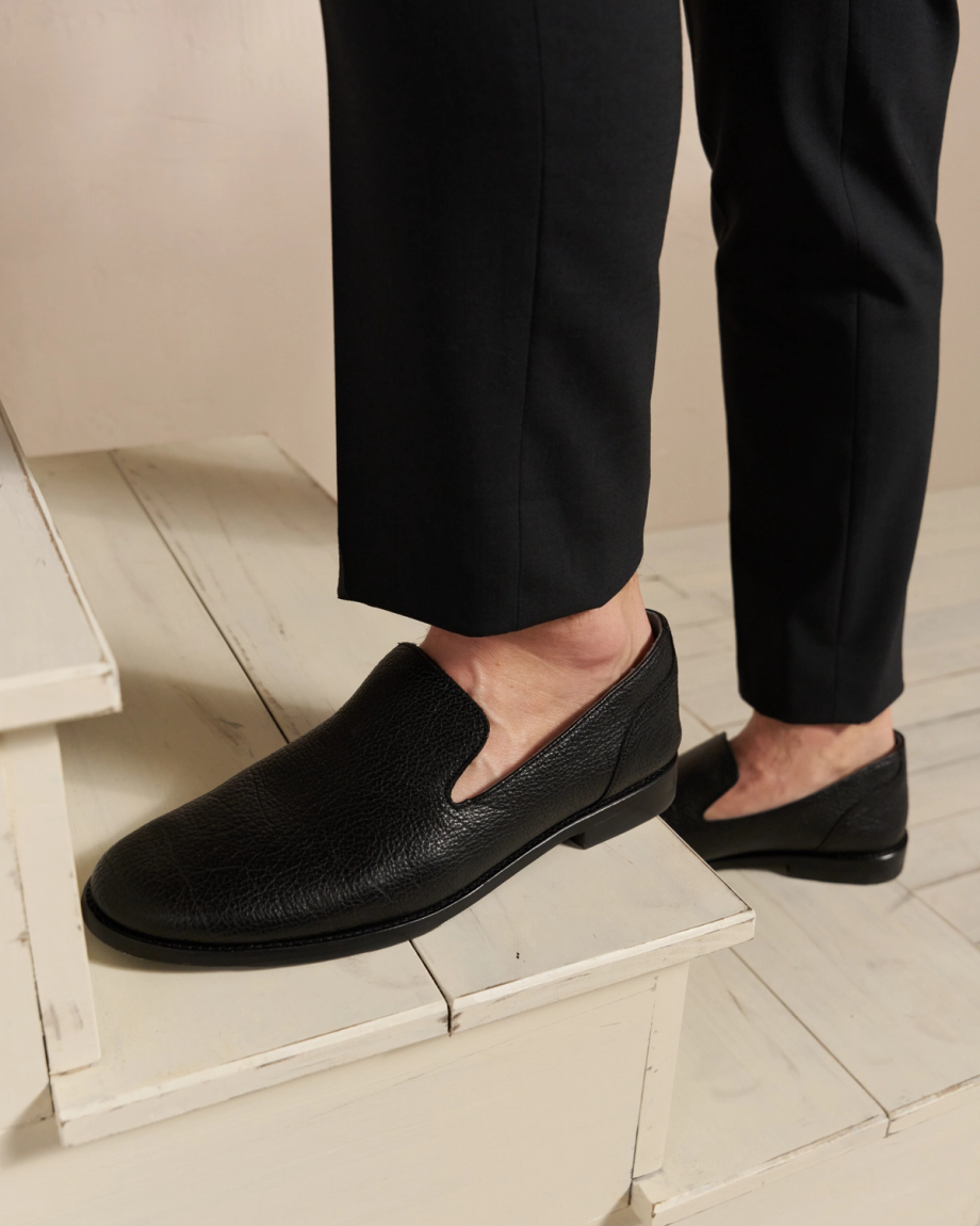 Person standing on stairs wearing the monterrey slip ons in the color midnight. 