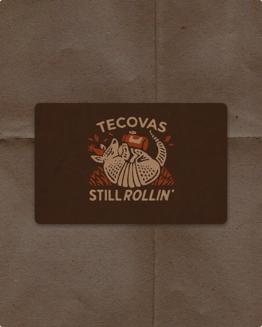 A sticker featuring an illustration of an armadillo wearing a party hat and holding a drink, with the text “TECOVAS STILL ROLLIN’”.