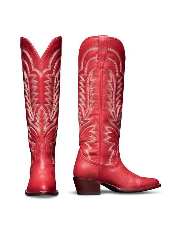 The Abby Wide Calf in Crimson Cowhide. A pair of tall Crimson Cowhide cowboy boots with white decorative stitching and angled heels, shown from the front and side on a white background.