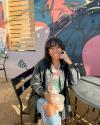 A woman sitting at a table in front of a mural.