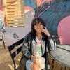 A woman sitting at a table in front of a mural.