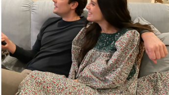 Man and woman looking away sitting on a couch