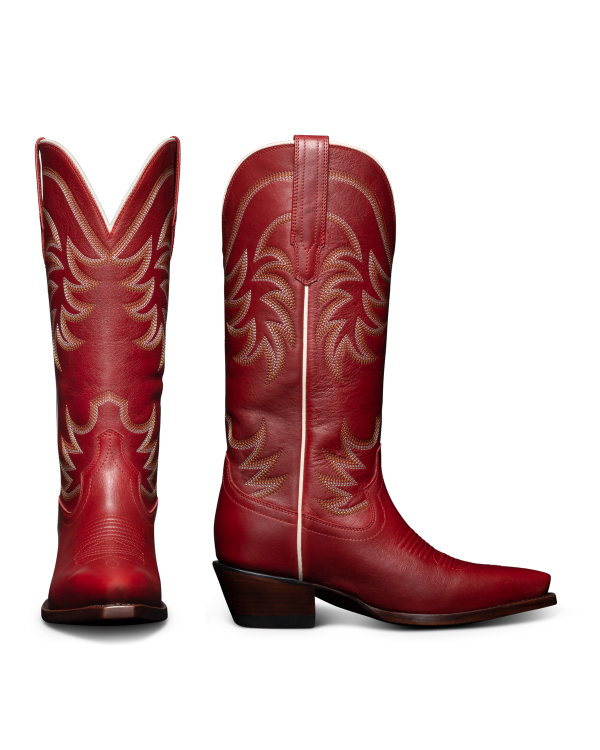 Two red cowboy boots with intricate stitching. One boot is shown from the front and the other from the side, displaying a pointed toe and a low heel, set against a black background.