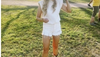 Woman in white cowboy hat, jean cutoff shorts and ostrich boots