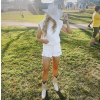 Woman in white cowboy hat, jean cutoff shorts and ostrich boots