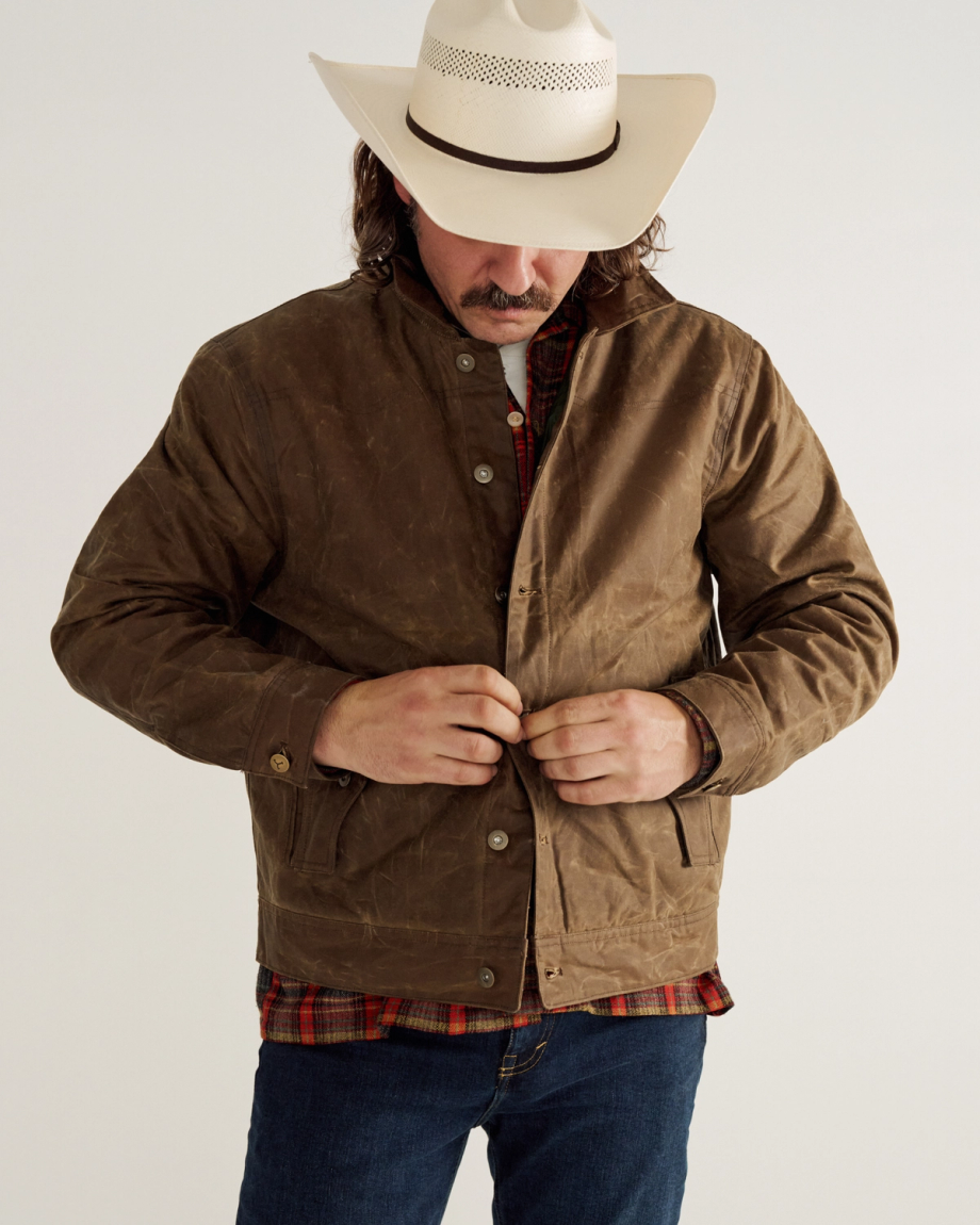 Man wearing the waxed canvas trucker jacket and a cowboy hat