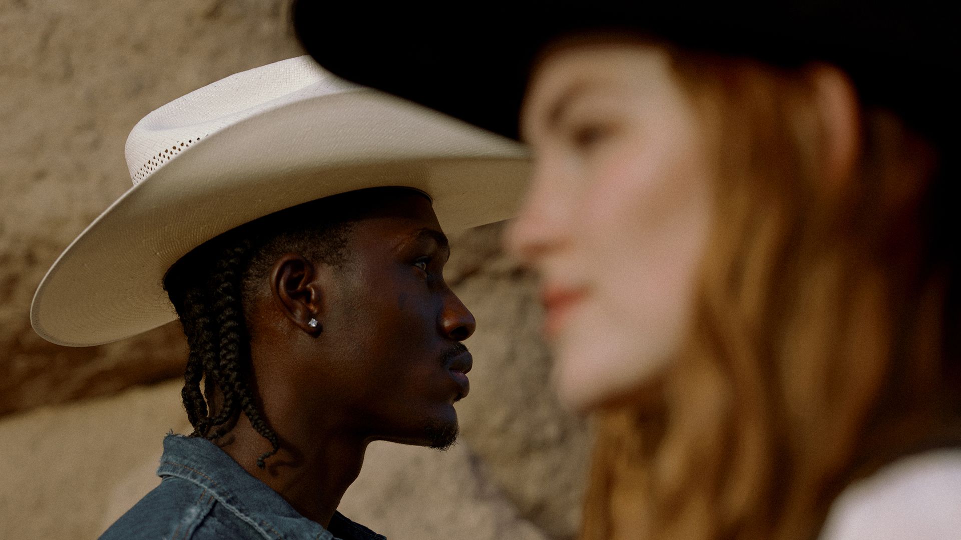 two people wearing cowboy hats facing eachother