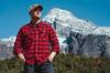 man in a red plaid shirt in front of a mountain