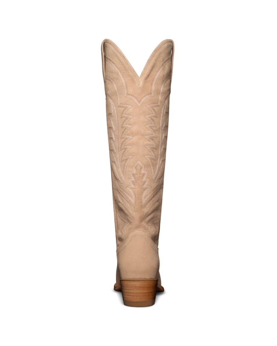 Back view of a beige cowboy boot with decorative stitching on the shaft, against a black background.