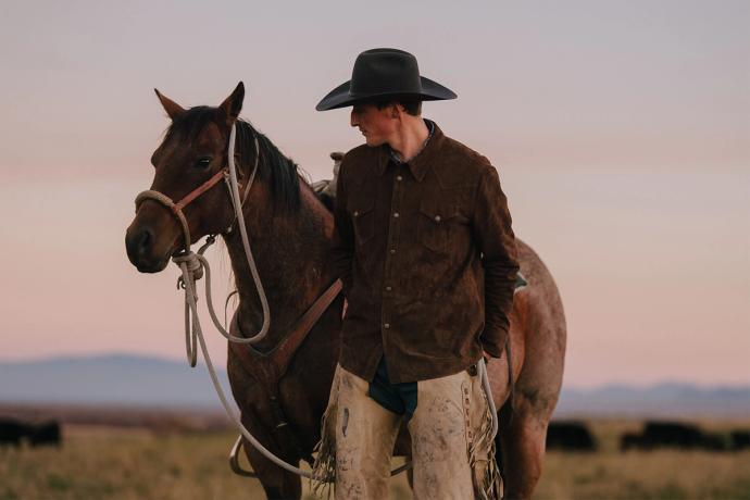 man by a horse in a field