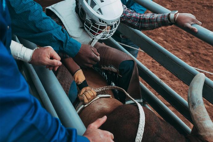 person getting on a bull at a rodeo