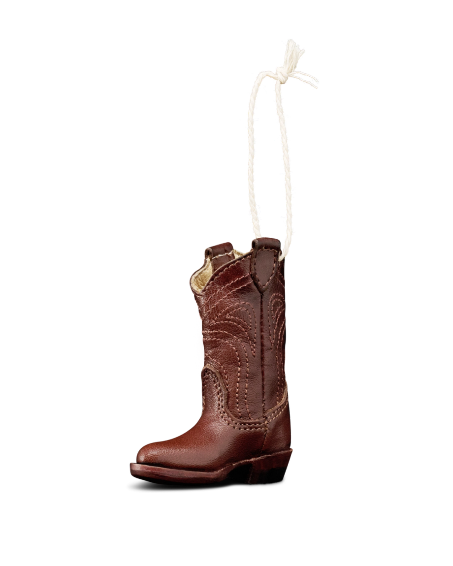 A small brown cowboy boot ornament with decorative stitching and a white hanging loop attached at the top, displayed on a plain white background.
