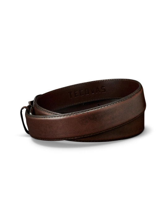 A rolled-up brown leather belt with the word "TECOVAS" embossed on the inside, displayed on a plain white background.